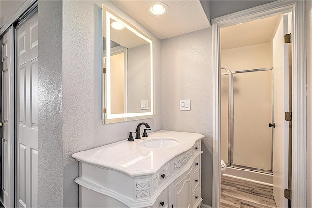 21318 S Briar Rd, Peculiar, MO 64078 - full bathroom featuring a textured wall, vanity, a shower stall, and wood finished floors