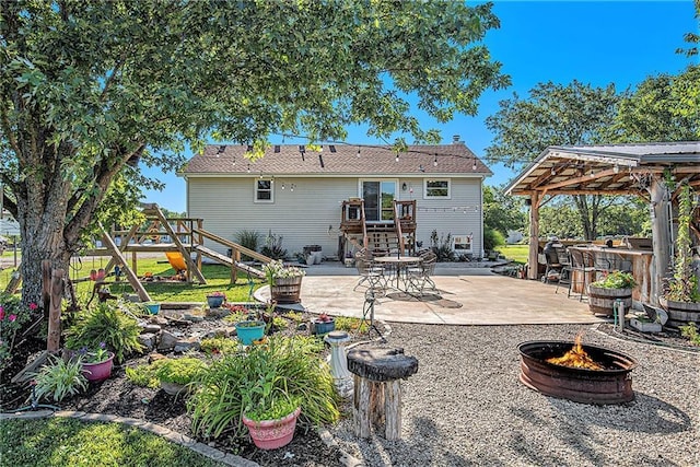 21318 S Briar Rd, Peculiar, MO 64078 - rear view of property featuring an outdoor fire pit, a patio, a gazebo, and a playground