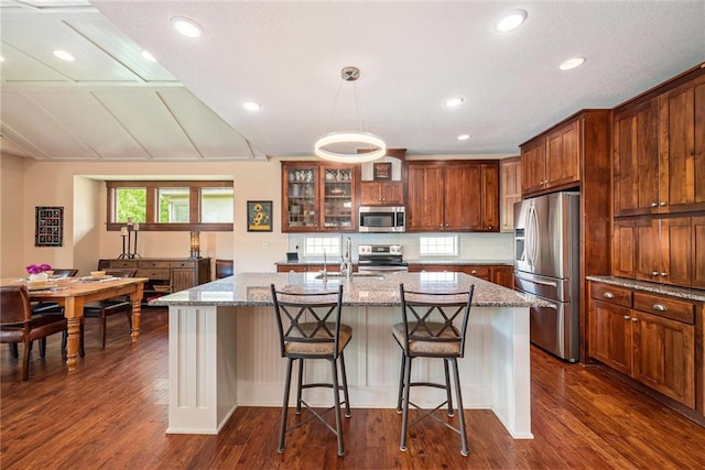 26793 W 100th Pl, Olathe, KS 66061 - kitchen featuring stainless steel appliances, dark wood finished floors, light stone counters, glass insert cabinets, and recessed lighting