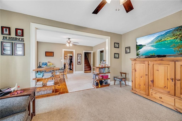 1002 S Olive St, Holden, MO 64040 - living room with ceiling fan, light carpet, and stairway
