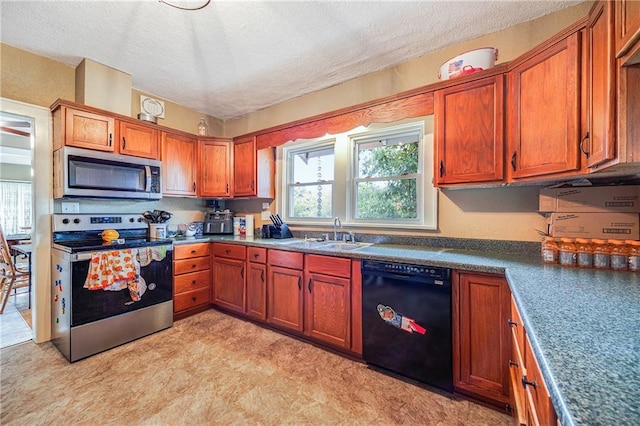 1002 S Olive St, Holden, MO 64040 - kitchen featuring appliances with stainless steel finishes, light flooring, plenty of natural light, a textured ceiling, and brown cabinets