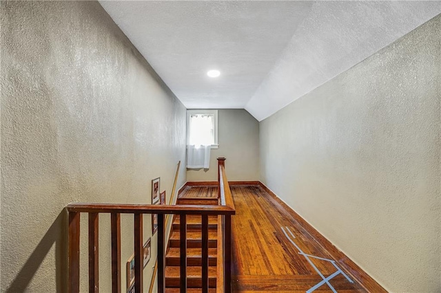 1002 S Olive St, Holden, MO 64040 - staircase featuring a textured wall, lofted ceiling, and wood finished floors