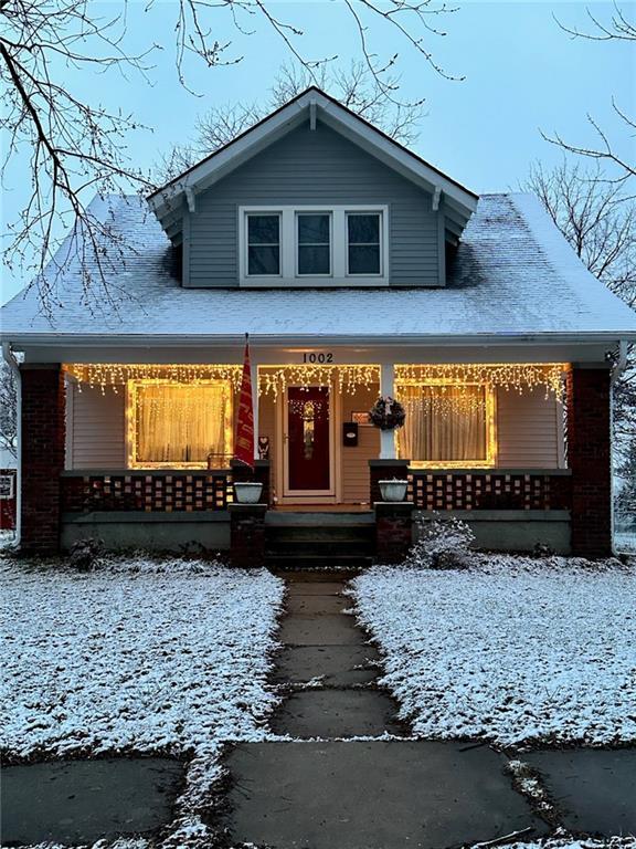 1002 S Olive St, Holden, MO 64040 - bungalow featuring covered porch and brick siding