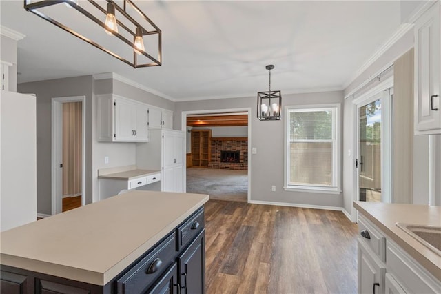 320 SW Raven Ct, Lees Summit, MO 64081 - kitchen with a chandelier, white cabinets, light countertops, pendant lighting, and a fireplace