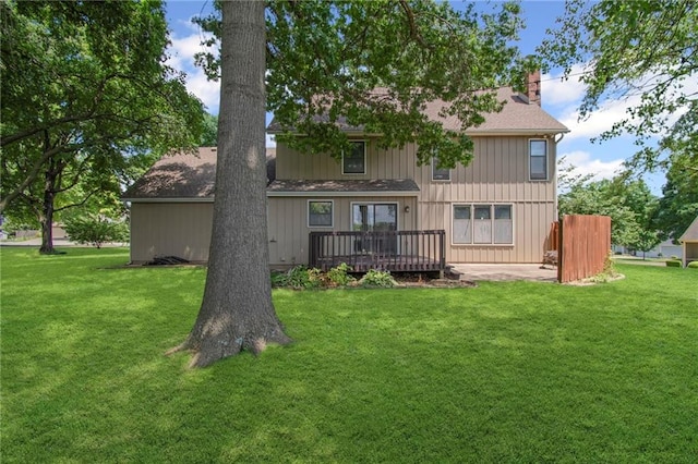 320 SW Raven Ct, Lees Summit, MO 64081 - rear view of property featuring a chimney, a wooden deck, a yard, and roof with shingles