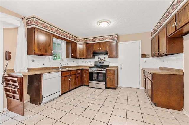 602 N Westview Dr, Richmond, MO 64085 - kitchen with gas stove, white dishwasher, under cabinet range hood, light countertops, and a textured ceiling