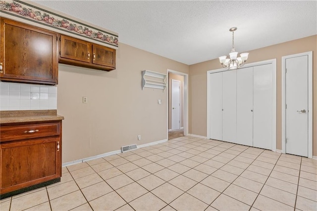 602 N Westview Dr, Richmond, MO 64085 - unfurnished dining area with a chandelier, a textured ceiling, and light tile patterned floors