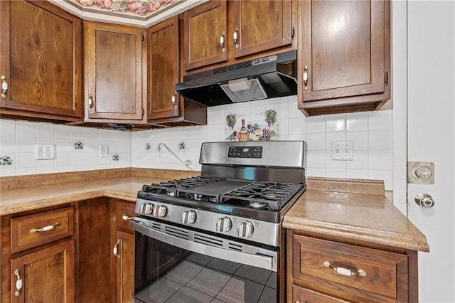 602 N Westview Dr, Richmond, MO 64085 - kitchen with gas stove, under cabinet range hood, tasteful backsplash, brown cabinets, and light countertops