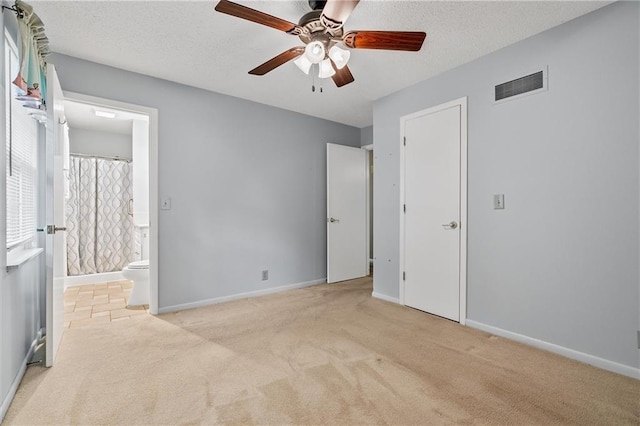 602 N Westview Dr, Richmond, MO 64085 - unfurnished bedroom with light colored carpet, connected bathroom, ceiling fan, and a textured ceiling