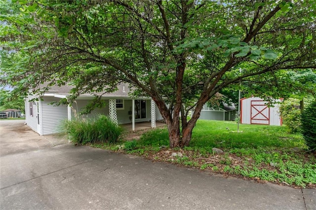 602 N Westview Dr, Richmond, MO 64085 - view of property hidden behind natural elements featuring a storage unit, concrete driveway, and a front lawn
