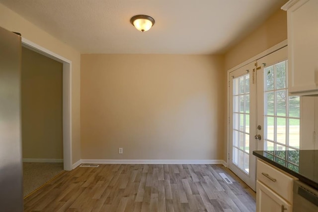 18205 E 27th St S, Independence, MO 64057 - unfurnished dining area with light wood-style flooring, healthy amount of natural light, and french doors