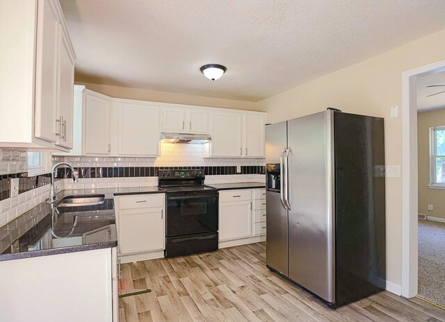 18205 E 27th St S, Independence, MO 64057 - kitchen with stainless steel fridge with ice dispenser, black electric range oven, under cabinet range hood, dark countertops, and light wood finished floors