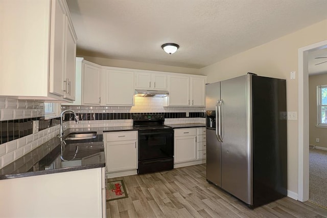 18205 E 27th St S, Independence, MO 64057 - kitchen with stainless steel fridge, black electric range, under cabinet range hood, dark countertops, and light wood finished floors