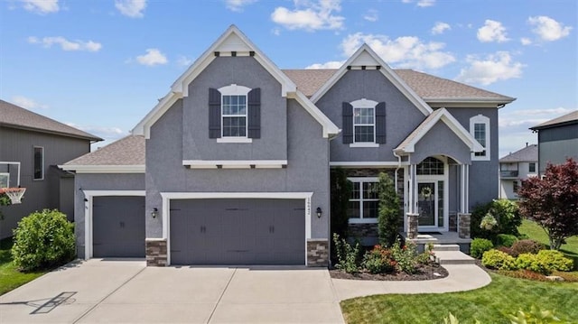 16642 W 165th St, Olathe, KS 66062 - view of front facade featuring driveway, stone siding, and stucco siding