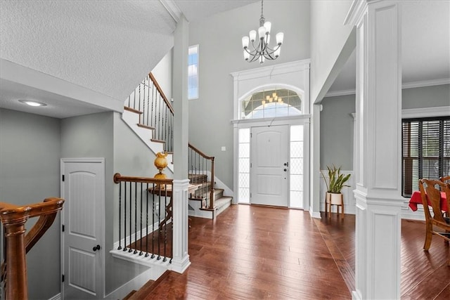 16642 W 165th St, Olathe, KS 66062 - entryway with a chandelier, wood-type flooring, a textured ceiling, a high ceiling, and stairs