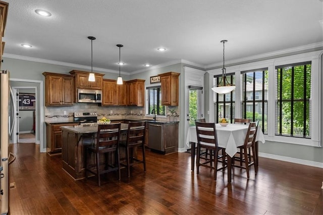 16642 W 165th St, Olathe, KS 66062 - kitchen featuring stainless steel appliances, a kitchen island, brown cabinets, dark wood-style floors, and recessed lighting