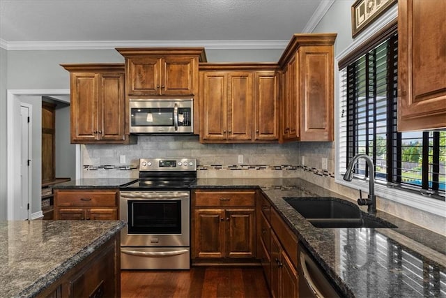 16642 W 165th St, Olathe, KS 66062 - kitchen with appliances with stainless steel finishes, dark wood-style floors, crown molding, backsplash, and dark stone counters