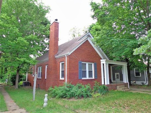 1915 S Elm St, Pittsburg, KS 66762 - view of property exterior featuring a chimney, brick siding, and a lawn