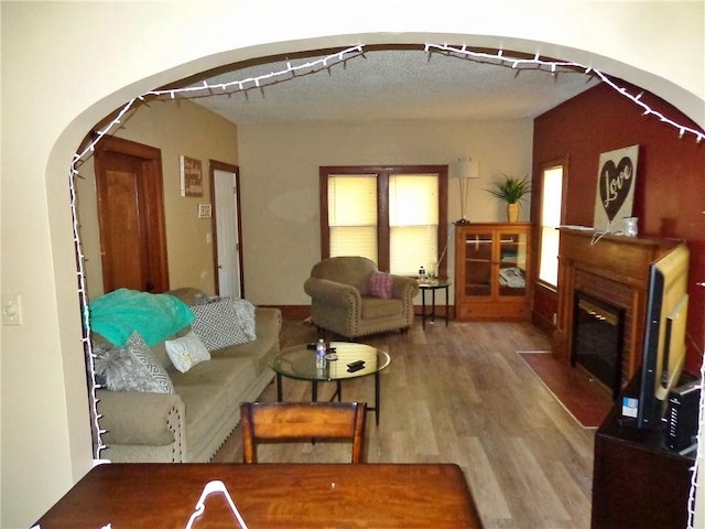 1915 S Elm St, Pittsburg, KS 66762 - living area featuring arched walkways, wood finished floors, and a fireplace with flush hearth