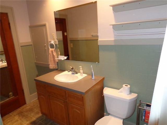 1915 S Elm St, Pittsburg, KS 66762 - bathroom with vanity, a wainscoted wall, and tile walls