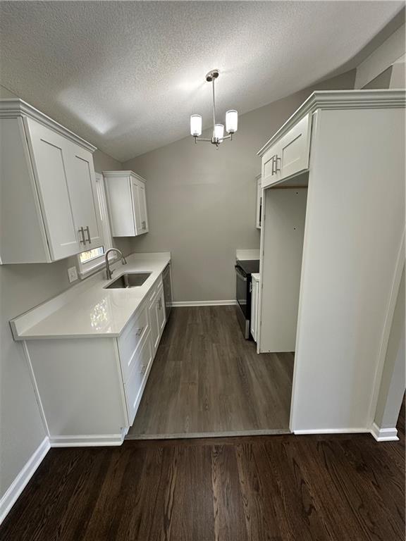 806 Lea Dr, Lees Summit, MO 64081 - kitchen with stainless steel range with electric stovetop, dark wood finished floors, light countertops, a textured ceiling, and white cabinetry