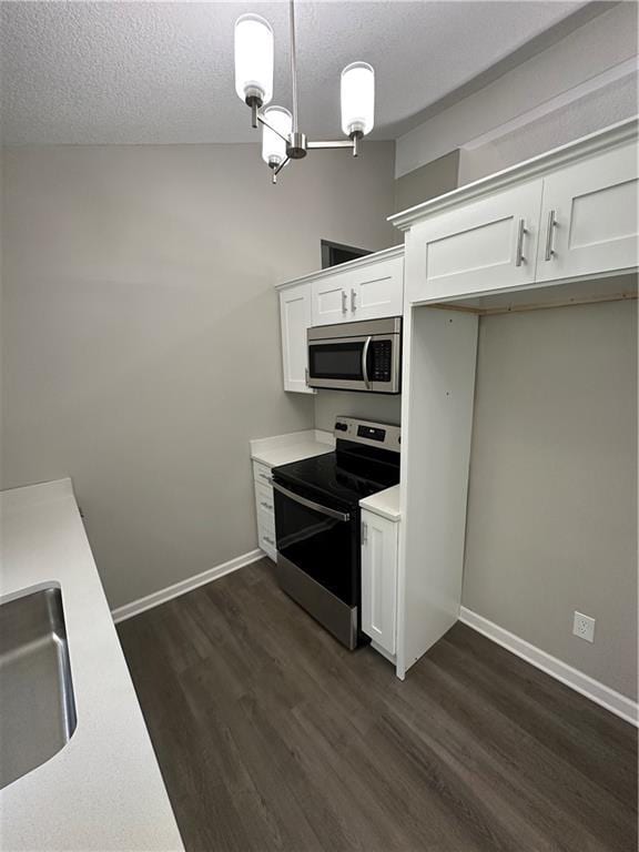 806 Lea Dr, Lees Summit, MO 64081 - kitchen featuring appliances with stainless steel finishes, light countertops, white cabinetry, dark wood-type flooring, and a textured ceiling