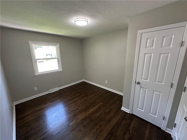 806 Lea Dr, Lees Summit, MO 64081 - spare room with a textured ceiling and dark wood-style floors