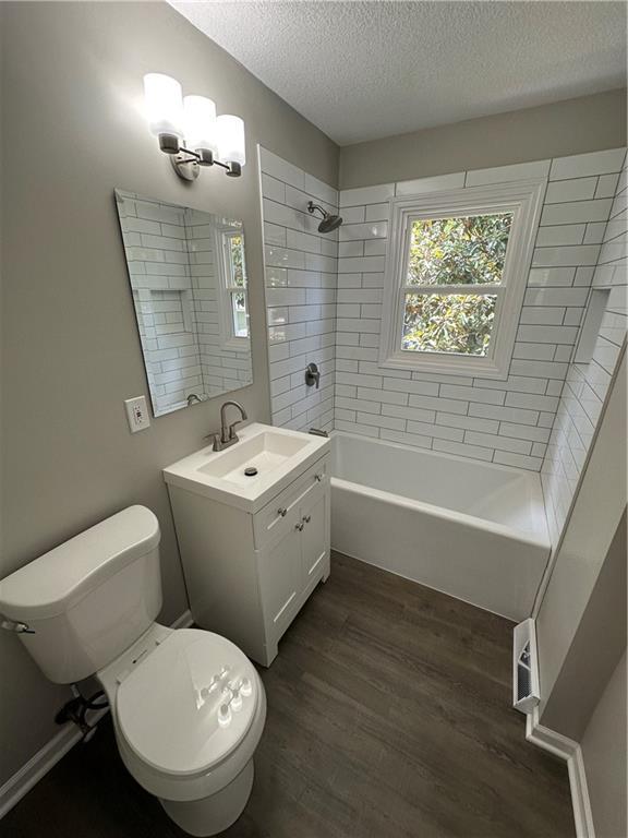 806 Lea Dr, Lees Summit, MO 64081 - bathroom with wood finished floors, a textured ceiling, bathtub / shower combination, and vanity