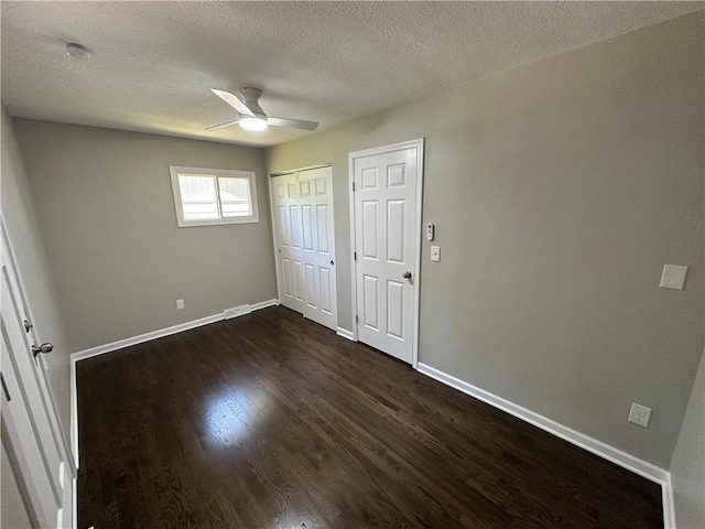 806 Lea Dr, Lees Summit, MO 64081 - unfurnished bedroom with dark wood-style floors, a textured ceiling, multiple closets, and ceiling fan