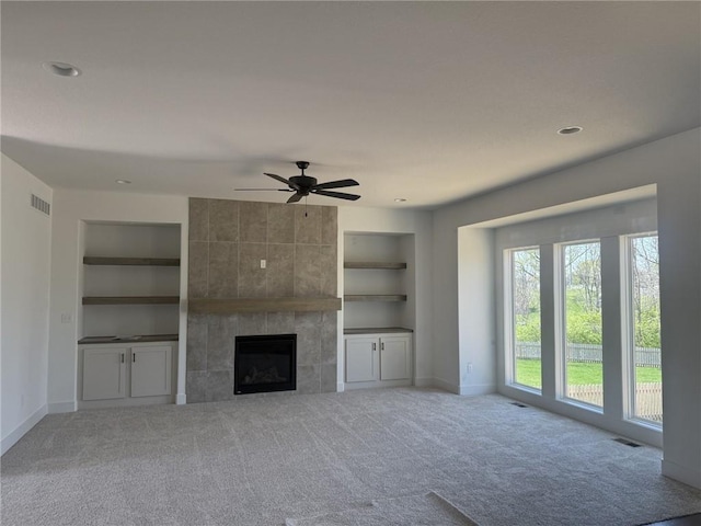 9011 N Colorado Ave, Kansas City, MO 64156 - unfurnished living room featuring built in features, carpet, a ceiling fan, a tiled fireplace, and recessed lighting