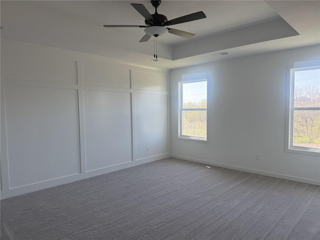 9011 N Colorado Ave, Kansas City, MO 64156 - unfurnished room featuring light carpet, a ceiling fan, a decorative wall, and a tray ceiling