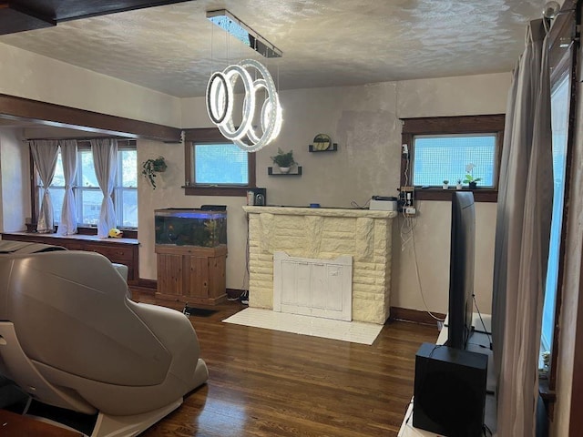 144 N Brighton Ave, Kansas City, MO 64123 - living room featuring wood finished floors, a textured ceiling, and a chandelier