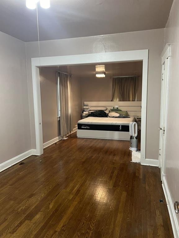 144 N Brighton Ave, Kansas City, MO 64123 - bedroom with dark wood-style flooring and baseboards