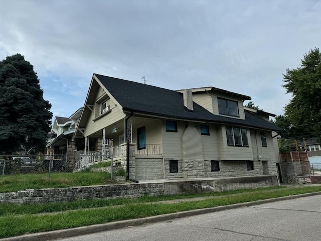 144 N Brighton Ave, Kansas City, MO 64123 - view of property exterior with stone siding and a porch
