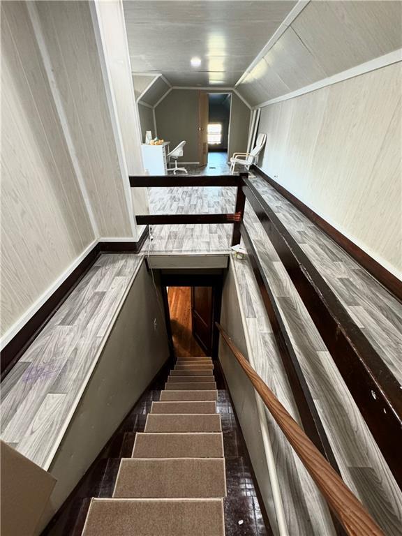 144 N Brighton Ave, Kansas City, MO 64123 - stairway featuring vaulted ceiling and baseboards