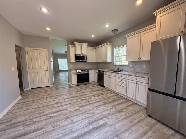 8808 NE 97th St, Kansas City, MO 64157 - kitchen with stainless steel appliances, light wood-style flooring, light stone countertops, backsplash, and recessed lighting
