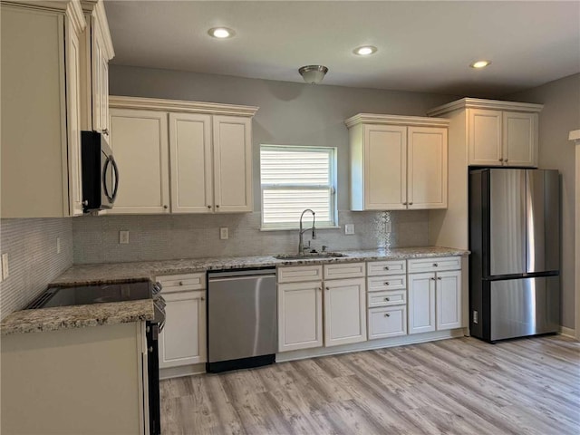 8808 NE 97th St, Kansas City, MO 64157 - kitchen featuring appliances with stainless steel finishes, backsplash, light wood-type flooring, and recessed lighting