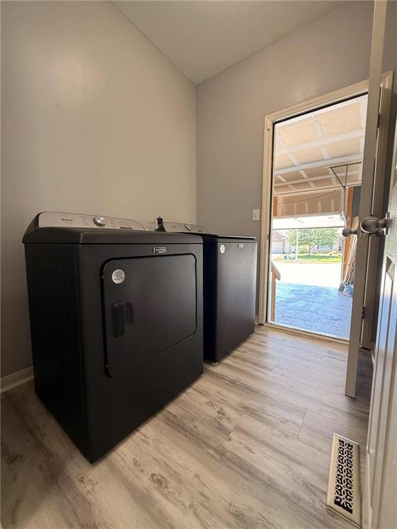 8808 NE 97th St, Kansas City, MO 64157 - washroom with washer / clothes dryer and light wood-type flooring