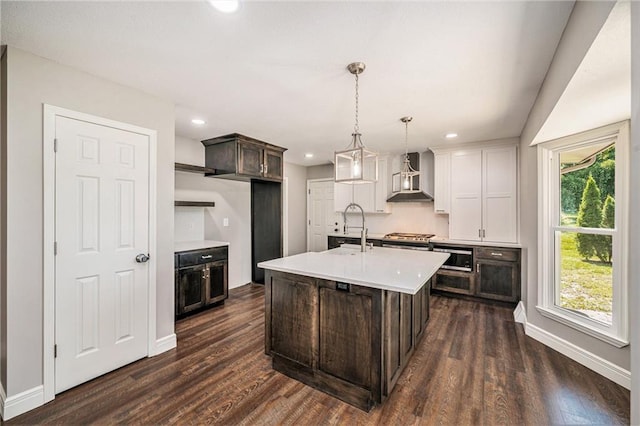 109 NE Locust St, Blue Springs, MO 64014 - kitchen featuring wall chimney range hood, light countertops, dark brown cabinetry, recessed lighting, and dark wood-style flooring
