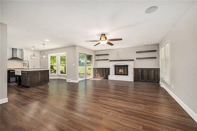 109 NE Locust St, Blue Springs, MO 64014 - unfurnished living room featuring a ceiling fan, dark wood-type flooring, a stone fireplace, and recessed lighting