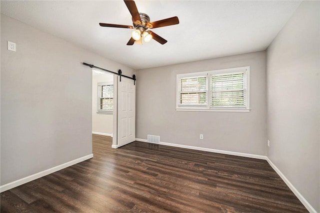 109 NE Locust St, Blue Springs, MO 64014 - unfurnished room with plenty of natural light, ceiling fan, a barn door, and dark wood finished floors