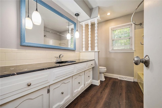 109 NE Locust St, Blue Springs, MO 64014 - full bath with vanity, washtub / shower combination, and wood finished floors