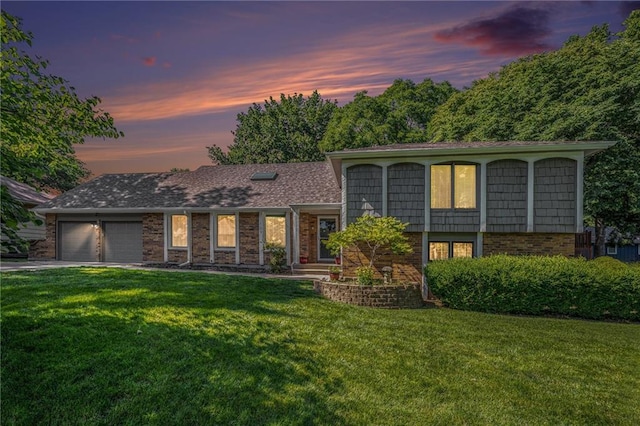 109 NE Locust St, Blue Springs, MO 64014 - split level home featuring a yard, brick siding, a garage, and driveway