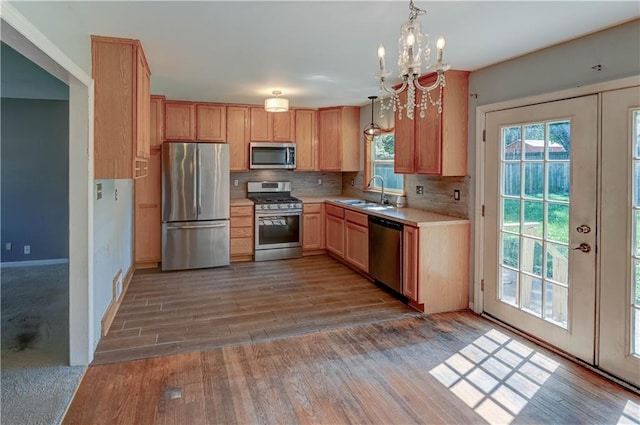 1700 S Pearl St, Independence, MO 64055 - kitchen featuring stainless steel appliances, light countertops, wood finished floors, and healthy amount of natural light