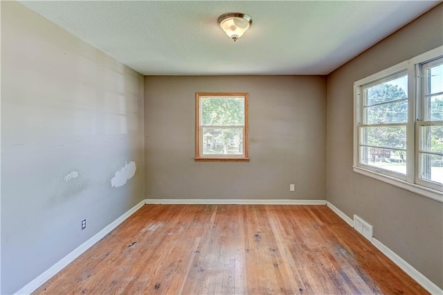 1700 S Pearl St, Independence, MO 64055 - empty room with healthy amount of natural light and light wood finished floors