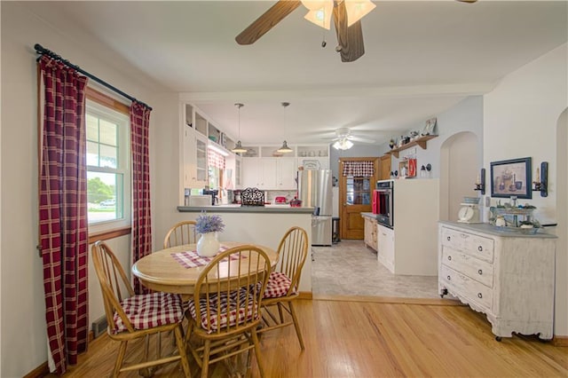 328 E 4th St, Lawson, MO 64062 - dining room featuring a ceiling fan, arched walkways, and light wood-type flooring