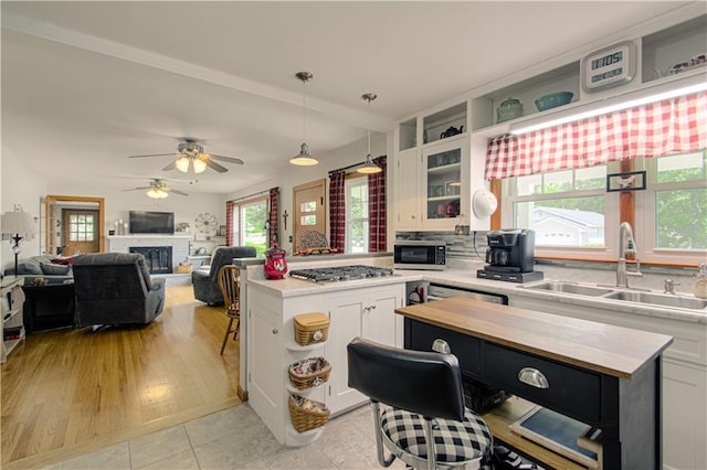 328 E 4th St, Lawson, MO 64062 - kitchen featuring a kitchen island, appliances with stainless steel finishes, white cabinets, and healthy amount of natural light