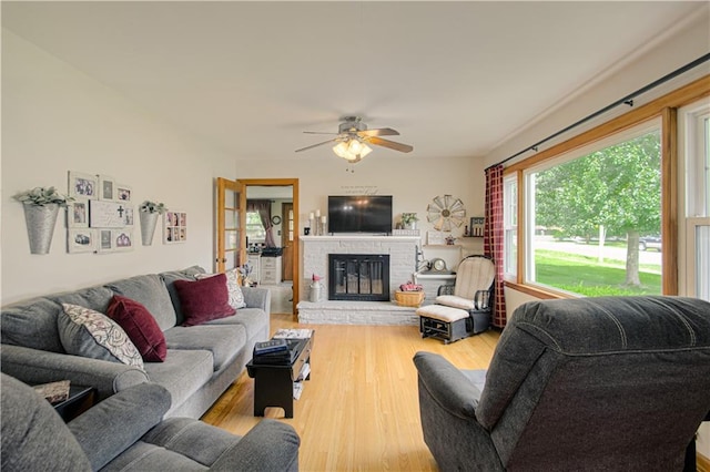328 E 4th St, Lawson, MO 64062 - living room with wood finished floors, a ceiling fan, and a fireplace