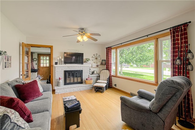 328 E 4th St, Lawson, MO 64062 - living area featuring plenty of natural light, a ceiling fan, wood finished floors, and a fireplace