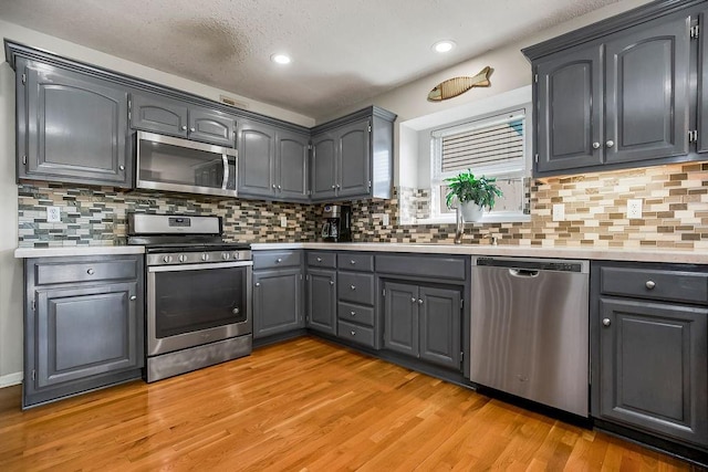 1311 Honeysuckle Ct, Liberty, MO 64068 - kitchen with appliances with stainless steel finishes, gray cabinetry, light countertops, and recessed lighting